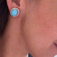 Arete azul con halo circular colocado en oreja