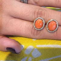 Par de aretes ovalados coral con halo brillante