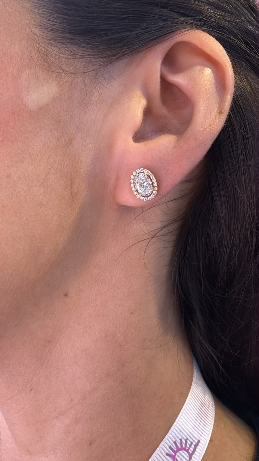 Arete ovalado con halo de diamantes de laboratorio en oro 14K puesto