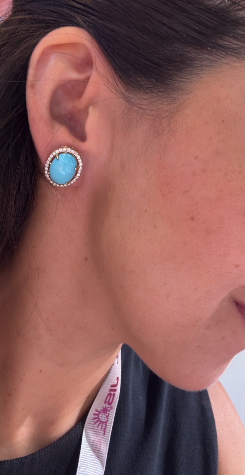 Arete azul con halo circular colocado en oreja