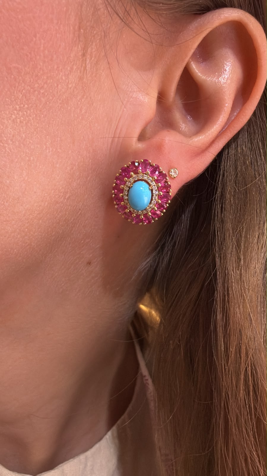 Arete azul turquesa y fucsia colocado en oreja