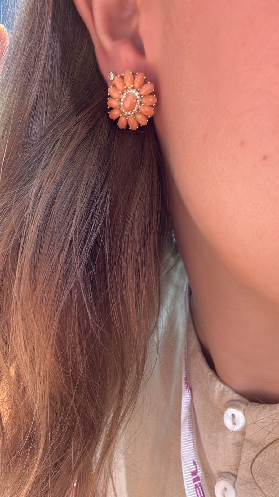 Arete floral coral colocado en oreja